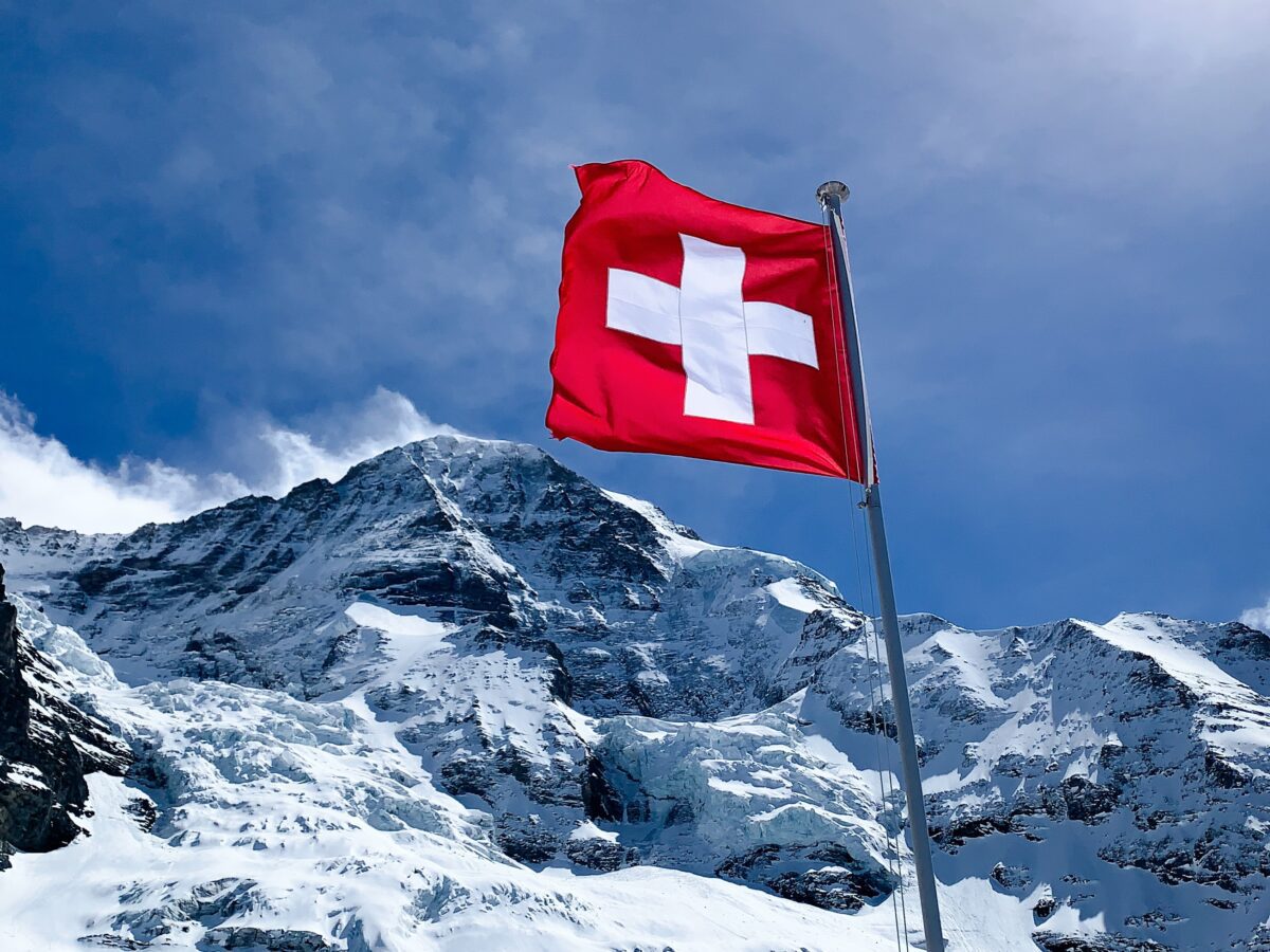Schweiz-Flagge vor Bergpanorama