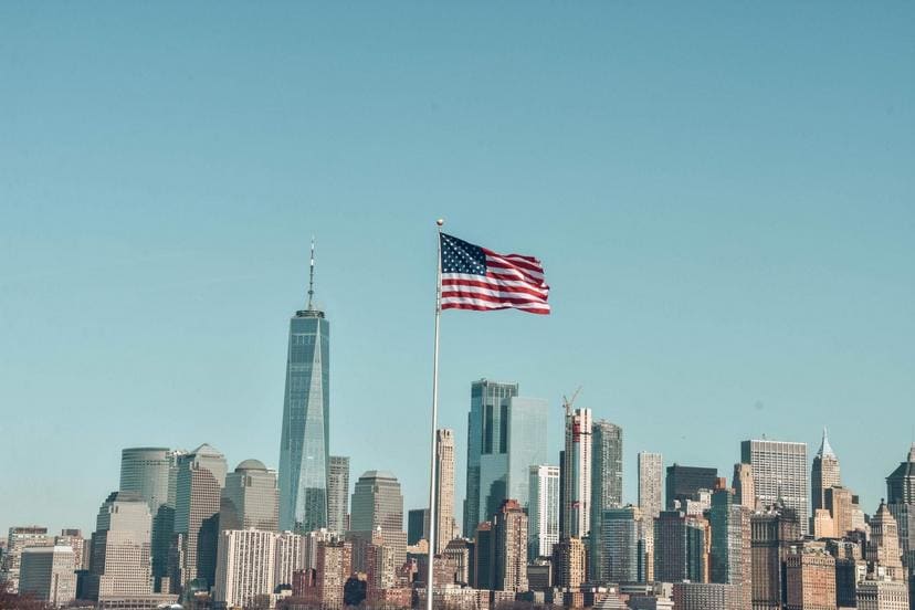 Amerikanische Flagge vor der Skyline von New York City, symbolisiert Verbrauchervertrauen und wirtsc.