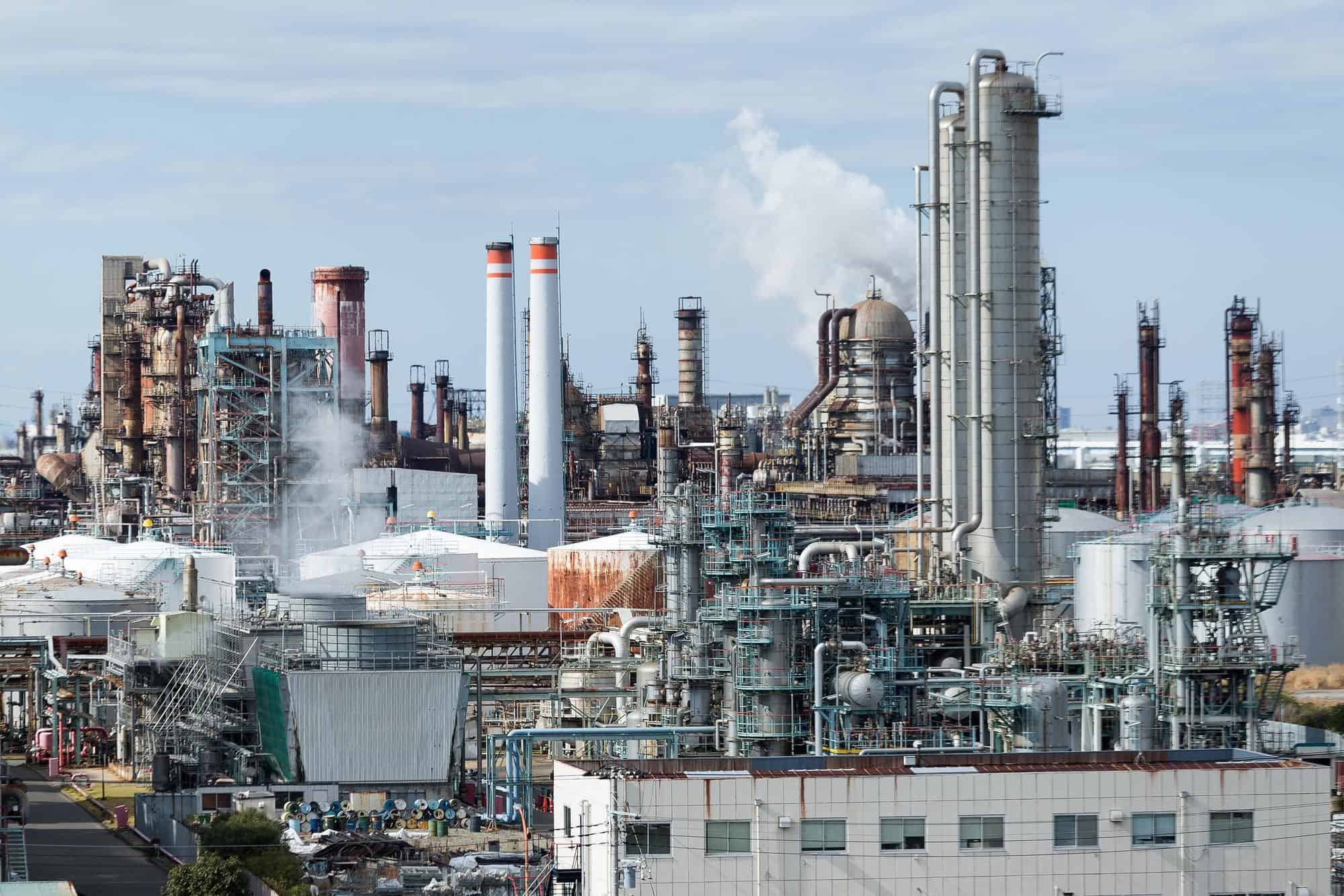 Industrielle Anlage in einer Chemiefabrik mit Emissionen, symbolisiert wirtschaftliche Herausforderu.