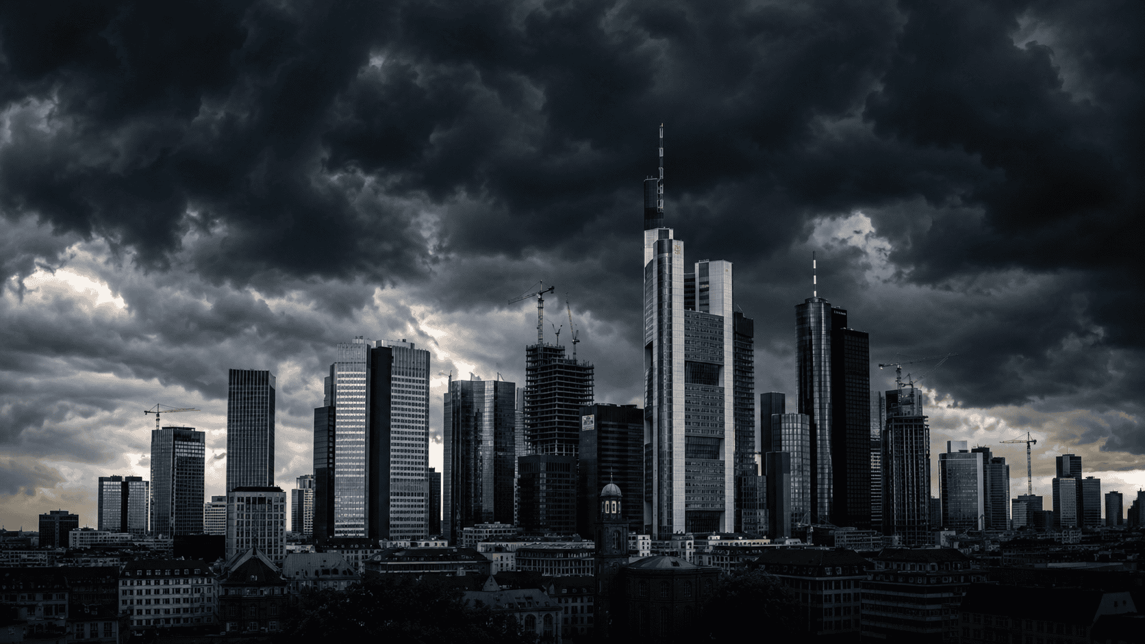 Dunkle Wolken über Frankfurts Skyline mit Hochhäusern und Baustellen.