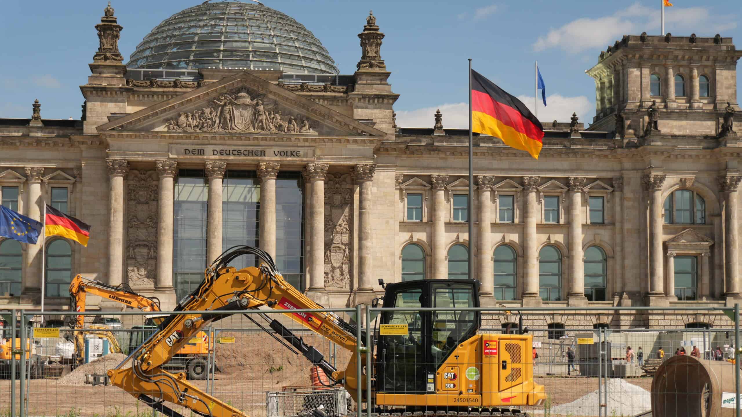 Bauarbeiten vor dem Reichstagsgebäude in Berlin mit Bagger und Absperrungen.