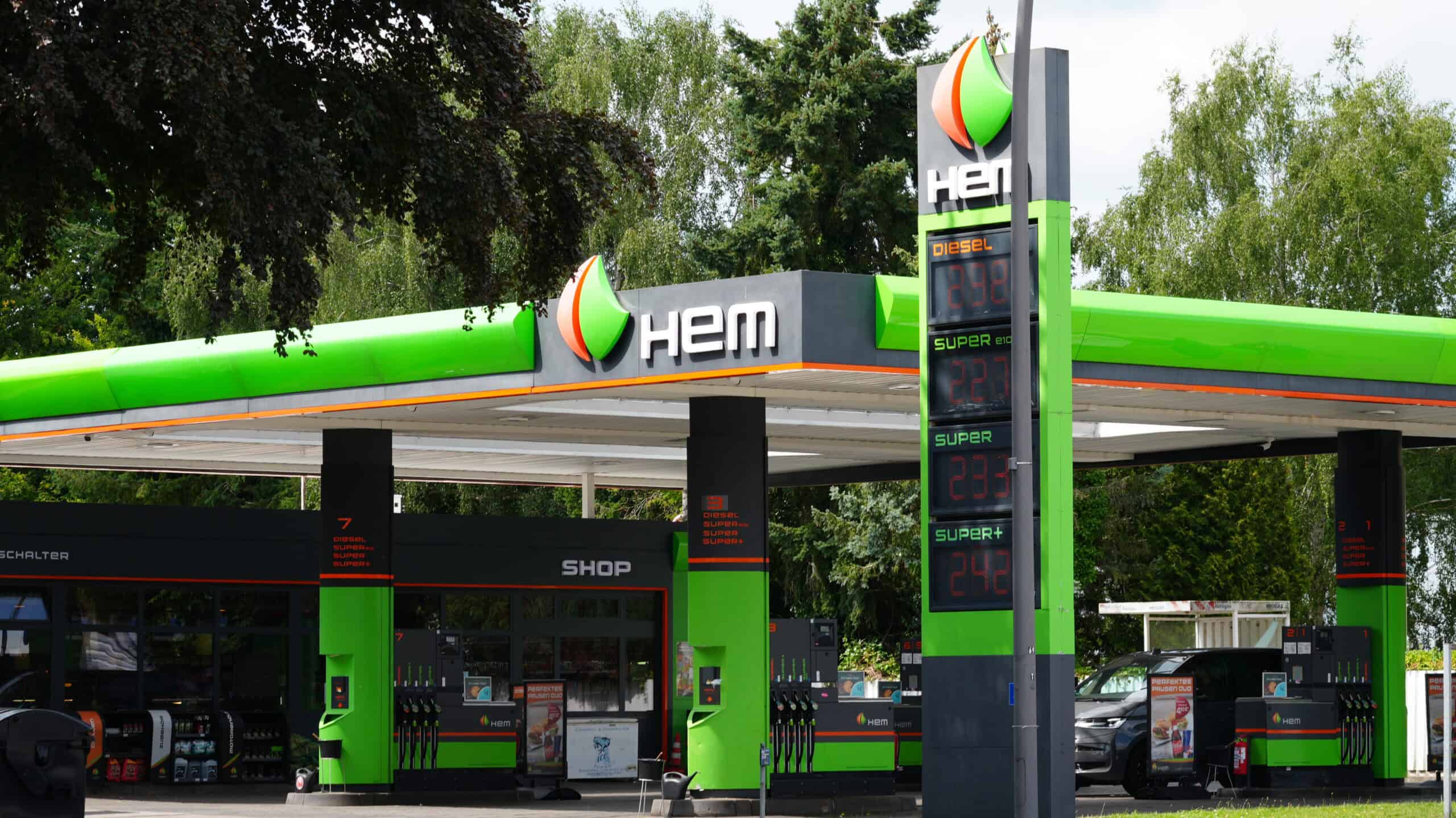 Tankstelle mit HEM-Logo und Preisschild in grüner Farbe.