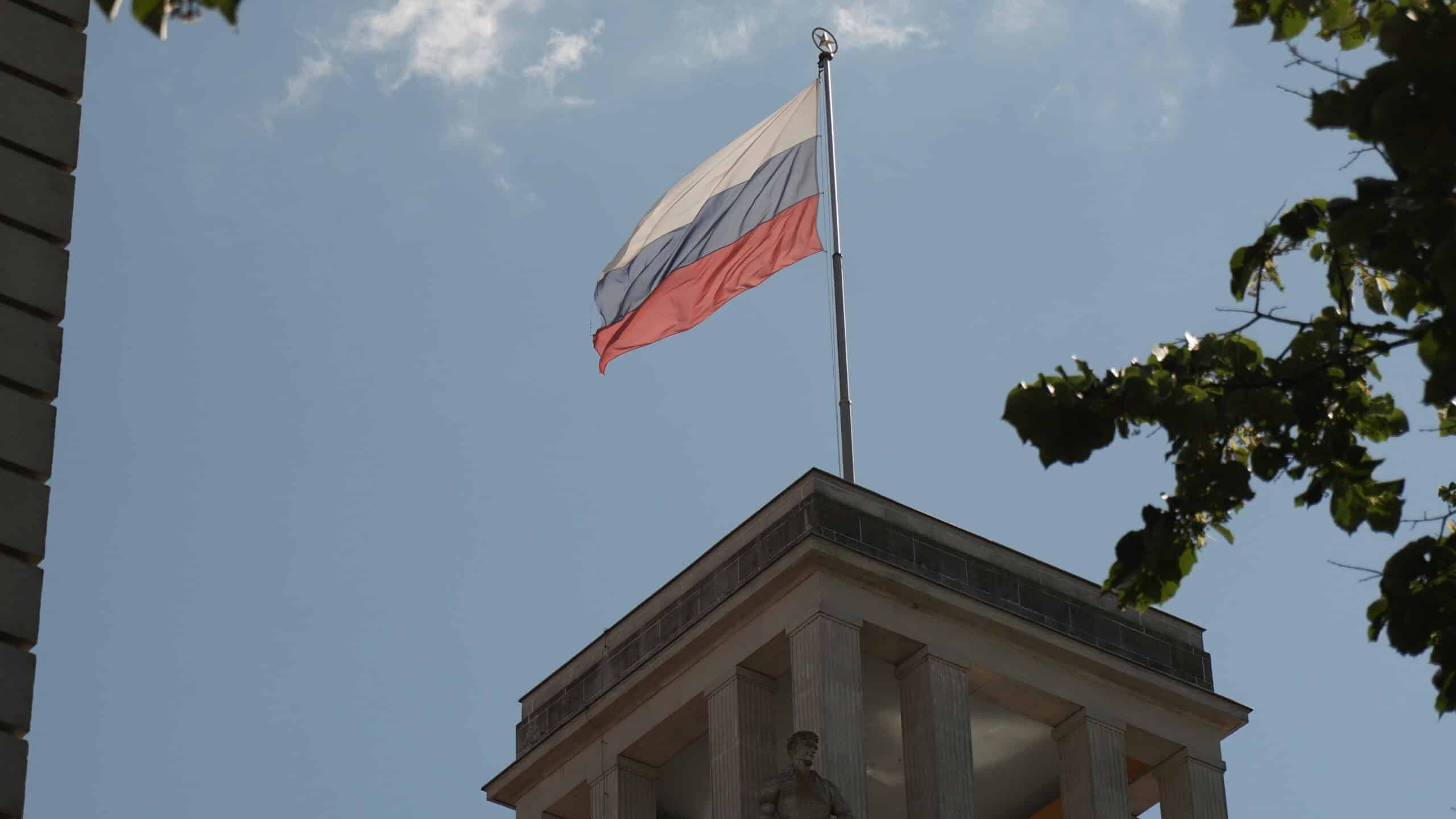 Polnische Flagge weht auf einem hohen Fahnenmast vor einem Gebäude.