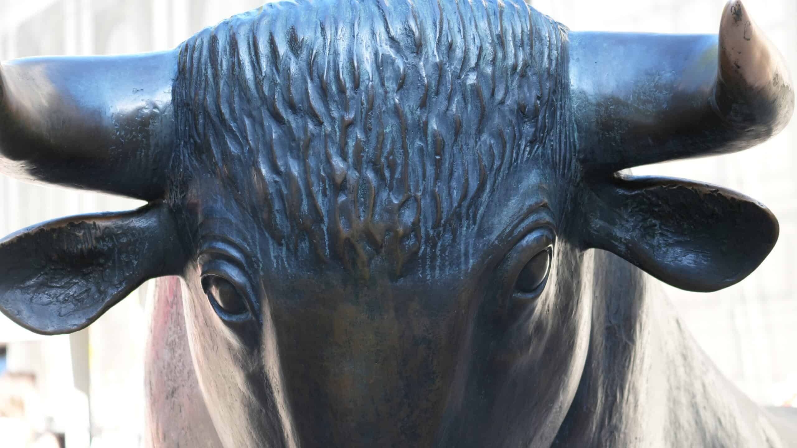 Bronzefarbene Bullenstatue mit detailreicher Textur und großen Hörnern.