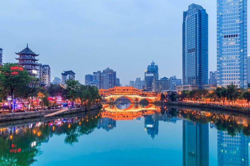 Moderne Skyline mit Fluss und Brücke bei Nacht in China.