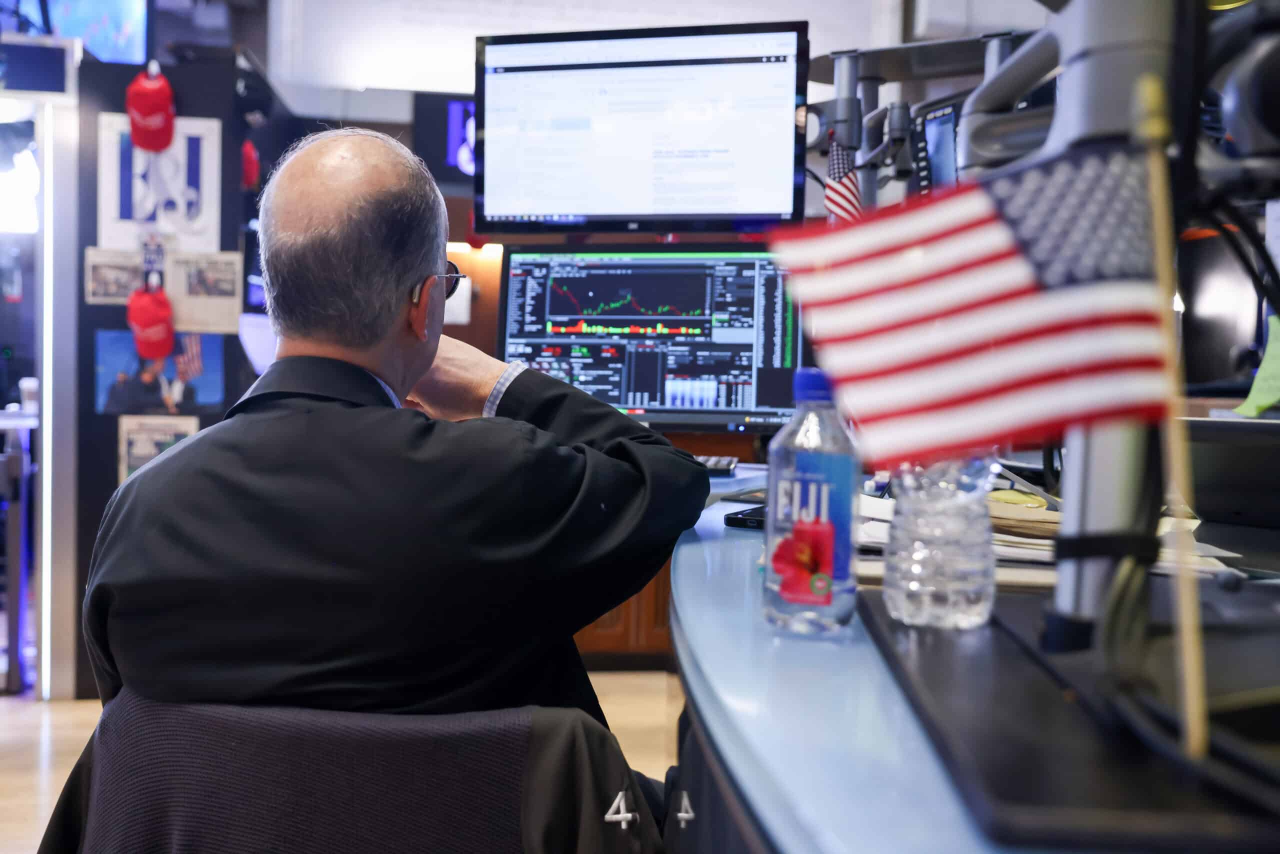 Börsenhändler überwacht Aktienkurse an mehreren Monitoren.